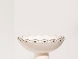 un bol blanc posé sur une table blanche