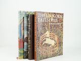 three books sitting on top of each other on a white surface