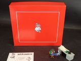 une image représentant une boîte rouge sur laquelle se trouve une petite figurine