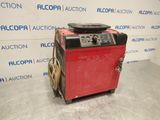 une machine rouge et noire posée sur un sol en béton