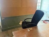 a desk with a chair in an empty room
