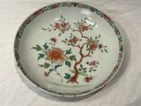 a plate with flowers and birds on it on a table