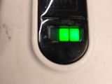 a close up of a green light on the back of a wii controller