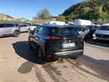 a black car parked in a parking lot next to other cars