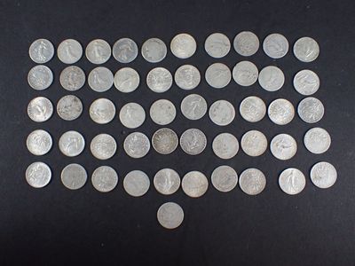 une image représentant un tas de pièces d'argent posées sur une surface noire