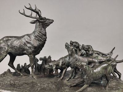 une statue représentant un cerf et un troupeau de chevreuils