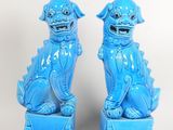 pair of blue foo foo foo statues on pedestals against a white background