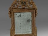an antique mirror with a gold frame and ornate decoration on the top
