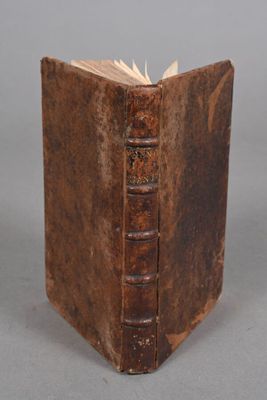 un vieux livre à la couverture brune posé sur une table