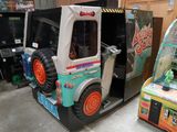 un camion miniature posé devant une borne d'arcade