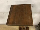a small wooden table with a metal base and a square wooden table top