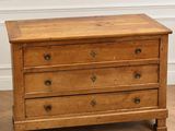 a wooden chest of drawers on a parquet floor in a room