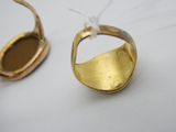 une bague en or et un miroir posés sur une table blanche