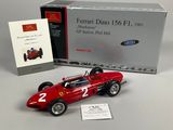 a red model of a racing car next to a boxed box