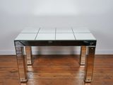 a glass and chrome coffee table on a wooden floor