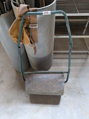 a metal bucket with a handle and a bag on it