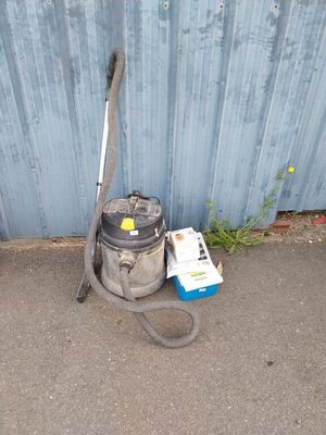 un aspirateur et un livre par terre, près d'un mur bleu