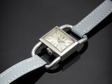 un gros plan d'une montre en argent avec un bracelet en cuir