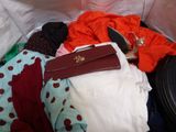 a suitcase full of clothes and a handbag on the bed
