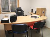 une photo d'un bureau avec un bureau et des chaises