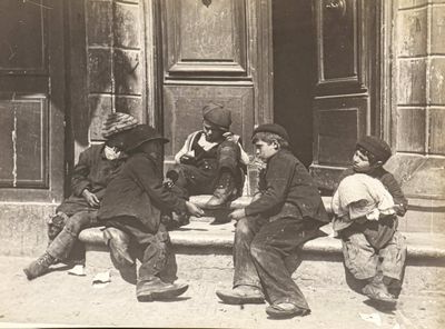 a group of children sitting on the steps outside of a building