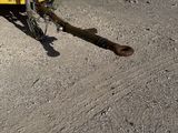 a rusted piece of metal on the ground next to a yellow container