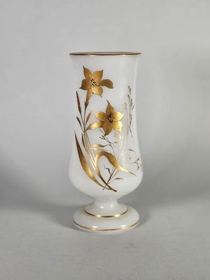 vase doré et blanc orné de fleurs sur un fond blanc