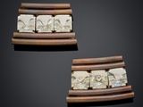two pieces of carved ivory and wood on a black surface