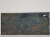 a piece of metal on the wall with a tag on it