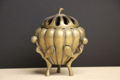 un petit objet métallique posé sur une table, sur fond noir