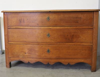 une commode en bois dans une pièce équipée d'un radiateur