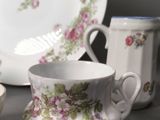 a cup and saucer sitting on a table next to a plate