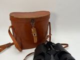 an old pair of binoculars sitting on top of a brown bag