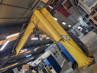 a yellow crane that is sitting in a warehouse