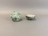 a small vase and a small bowl sitting on a table