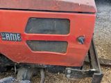 a red tractor that is parked in the dirt