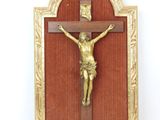 a gold crucif on a red wall with a gold frame