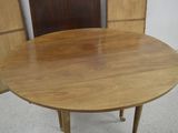 a round table with a wooden top on a white floor