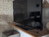 a flat screen tv on a shelf above a toaster