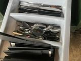 a person holding a tray with silverware in it
