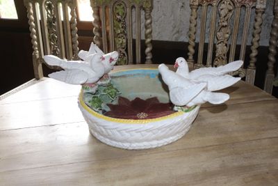 two white birds that are sitting in a bowl on a table