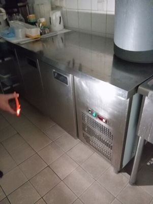 un homme debout dans une cuisine, une carotte à la main