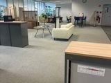 une photo d'un bureau avec un réfrigérateur et une table