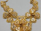 a close up of a gold necklace on a gray surface