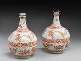 deux vases orange et blancs posés sur une table