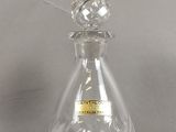 une bouteille en verre transparent ornée d'une étiquette dorée