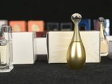 bottles of perfume are lined up in a row on a black surface