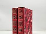 two red books sitting on top of each other on a table