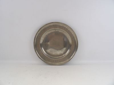 une plaque d'argent sur une surface blanche avec un fond blanc