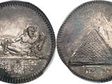 an image of a silver coin with an image of a woman and a pyramid on it